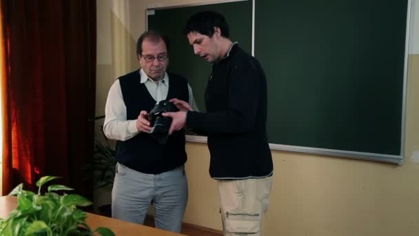 Eğitmen dijital fotoğraf makinesi ile çalışmak nasıl bir katılımcıya açıklayan — Stok video
