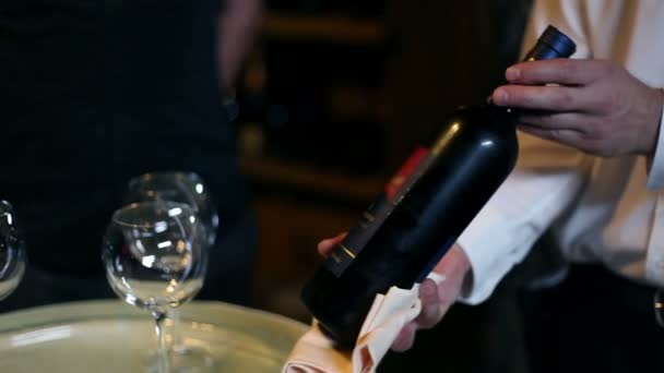 Официант показывает бутылку вина своим клиентам — стоковое видео