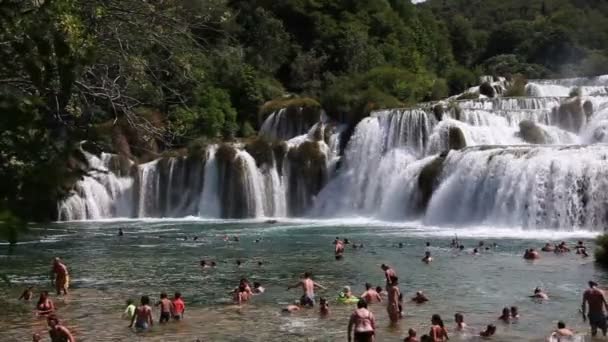 Фотография туристов, плавающих перед водопадом в национальном парке Крка — стоковое видео