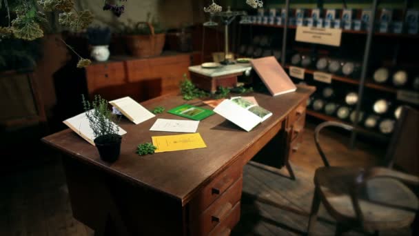 Man reading a book in an old office for drying herbs — Stock Video