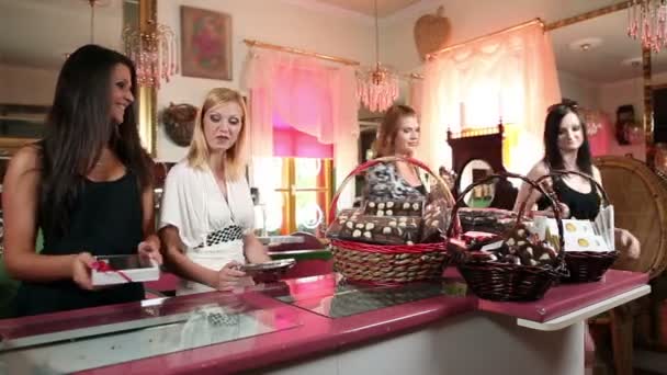 Atractivas mujeres jóvenes que salen de la tienda de chocolate — Vídeo de stock