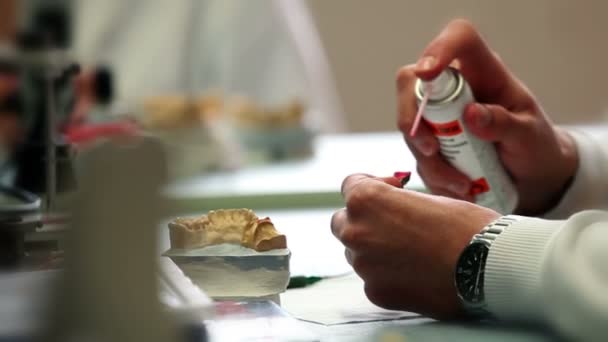 Dentist cleans and repairs dentures — Stock Video