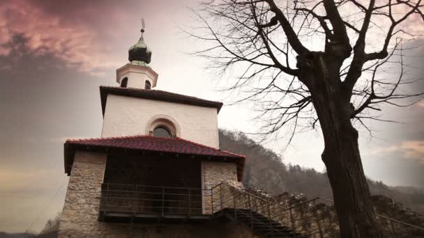 Фасад церкви и дерево перед ней с движущимися облаками — стоковое видео