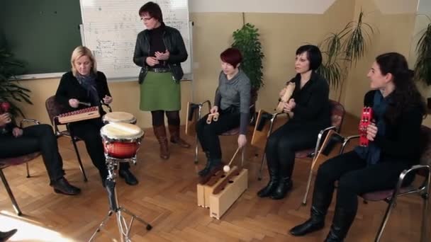 Rechts naar links pan schot van de groep van mensen die een nieuw lied aan het leren bent — Stockvideo