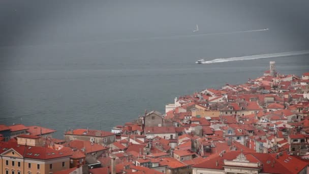 Выстрел из Piran с холма над ним и некоторые лодки на море — стоковое видео