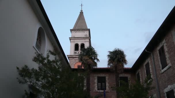 Постріл церковної вежі з подвір'ям попереду — стокове відео