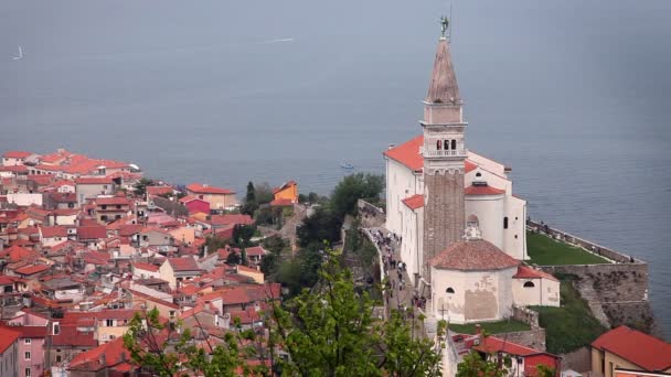 Zoom in of Piran's church with the sea in behind — Stock Video