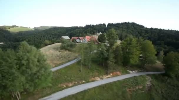 Panorama slide shot de poucas casas na colina cercada por florestas verdes — Vídeo de Stock