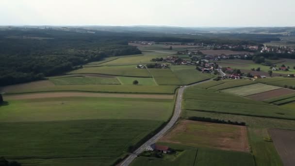 Панорамный слайд с вертолета, представляющего холмы и долину в центре, который населен несколькими домами — стоковое видео