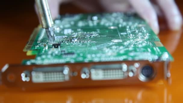 Shot of a man solder a chip on a graphics card — Stock Video