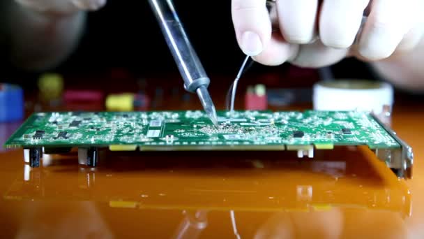 Shot of a man solder a chip on a graphics card — Stock Video