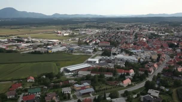 Panorama slide tiro de helicóptero representando um vale povoado com algumas casas e pequeno lago no lado direito desta paisagem — Vídeo de Stock