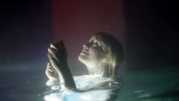 Femme dans la piscine extérieure la nuit — Video