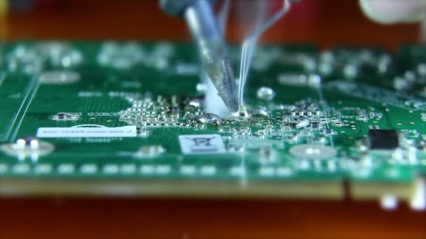 Shot of a man solder a chip on a graphics card — Stock Video