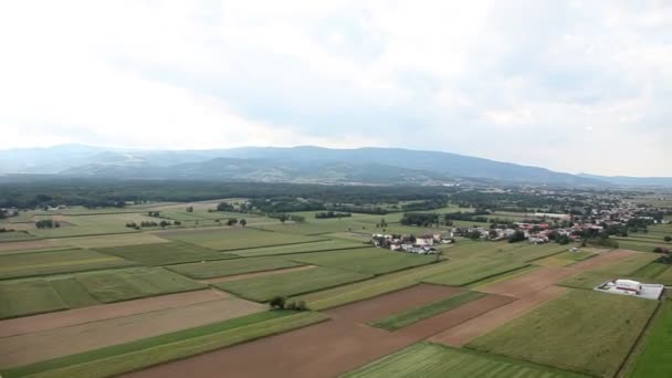 Panorama slajdów zdjęcia z helikoptera, wzgórza i doliny, w środku, która jest wypełniona kilka domów — Wideo stockowe