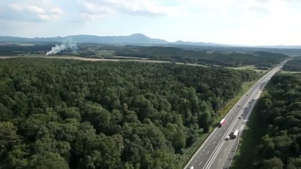 Panorama snímek z vrtulníku, představující krásné zelené údolí s dálnici uprostřed — Stock video