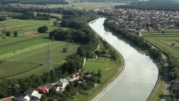 Панорамний слайд, знятий з вертольота, що представляє русло річки, який повільно проходить через красиву зелену долину з невеликими селами біля річки — стокове відео