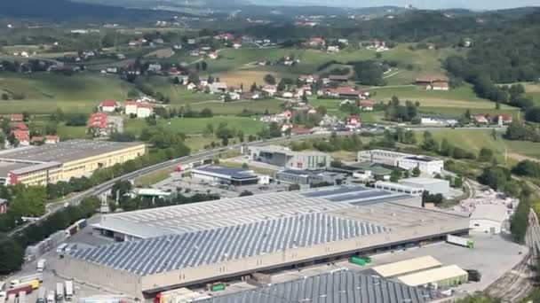 Panorama de diapositivas disparado desde helicóptero que representa una parte industrial de una pequeña ciudad con techos cubiertos con centrales solares — Vídeos de Stock