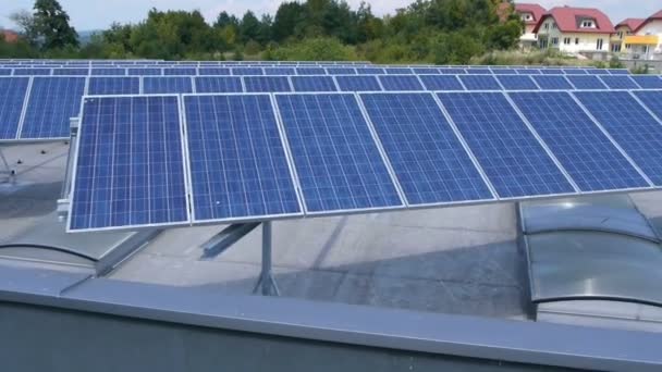 Vue panoramique depuis un hélicoptère représentant une partie industrielle d'une petite ville avec des toits couverts de centrales solaires — Video