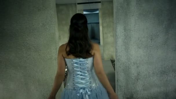 Mujer en un hermoso vestido azul caminando y bailando hacia el agua — Vídeo de stock