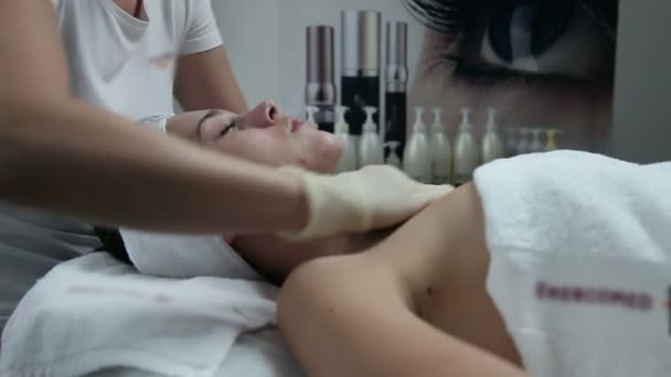 Mujer joven que tiene un cuidado facial en un spa de belleza — Vídeos de Stock