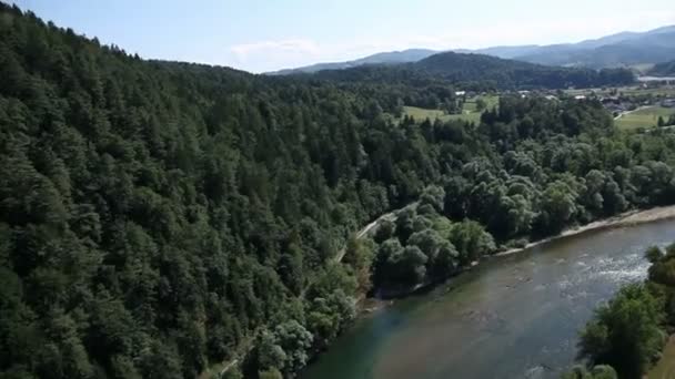 Panorama slide tiro de helicóptero representando o leito do rio que passa lentamente por um belo vale verde com pequenas aldeias ao lado do rio — Vídeo de Stock