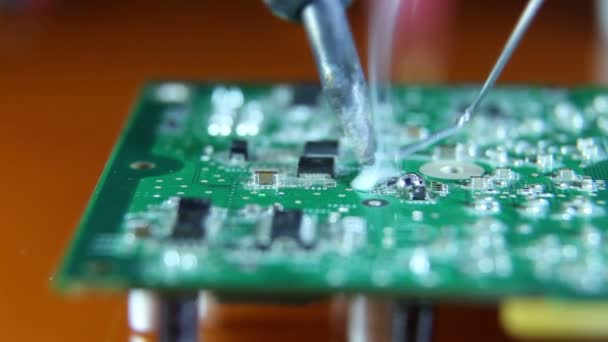 Shot of a man solder a chip on a graphics card — Stock Video