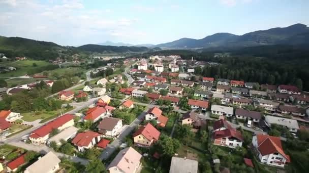 Panorama-Dia-Aufnahme aus dem Hubschrauber, die ein Tal mit einigen Häusern und einem kleinen See auf der rechten Seite dieser Landschaft darstellt — Stockvideo