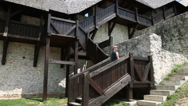 Girato di una giovane donna su una scala di un vecchio castello — Video Stock