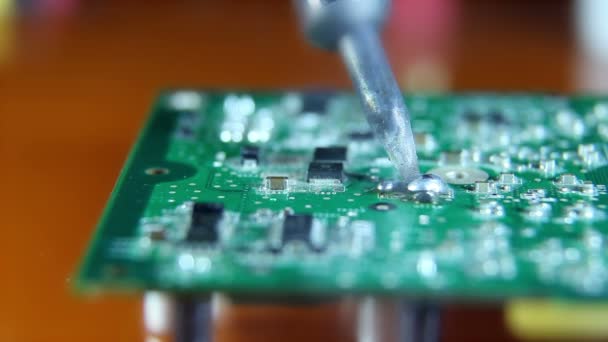 Shot of a man solder a chip on a graphics card — Stock Video