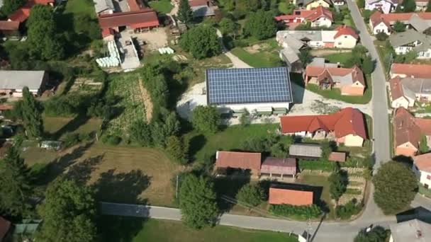 Panorama-Dia-Aufnahme aus dem Hubschrauber, die ein Tal mit einigen Häusern und einem kleinen See auf der rechten Seite dieser Landschaft darstellt — Stockvideo