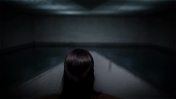 Mulher em um belo vestido tocando superfície da água e criando padrão de reflexão no teto — Vídeo de Stock