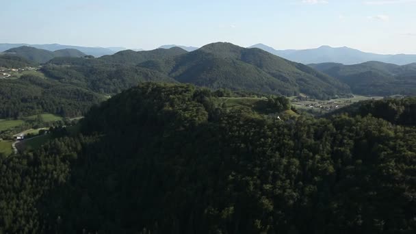 Vue panoramique depuis un hélicoptère représentant des collines couvertes de forêts vertes 