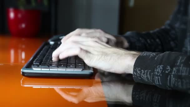 Tiro de manos de un hombre escribiendo en un teclado de computadora — Vídeos de Stock