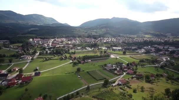 Vue panoramique depuis un hélicoptère représentant une vallée avec des champs, des prairies, une forêt et peu de maisons — Video