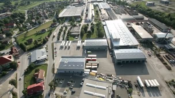Panorama slide shot de helicóptero representando uma parte industrial de uma pequena cidade com telhados cobertos com centrais solares — Vídeo de Stock