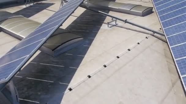 Vue panoramique depuis un hélicoptère représentant une partie industrielle d'une petite ville avec des toits couverts de centrales solaires — Video