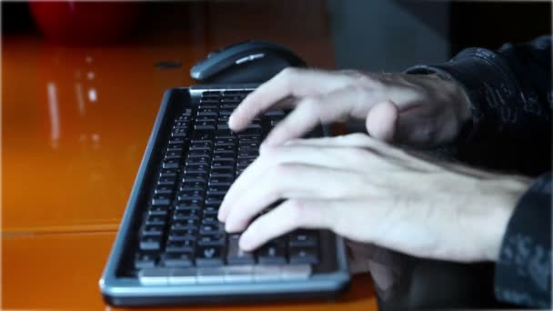 Tiro de manos de un hombre escribiendo en un teclado de computadora — Vídeos de Stock