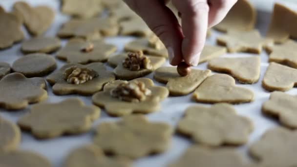 Close-up shot van een vers, net gesneden cookies op een dienblad en zetten op walnoten — Stockvideo