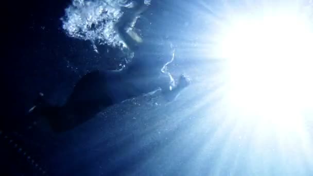 Junge, schöne Frau in Kleidung schwimmt unter Wasser — Stockvideo