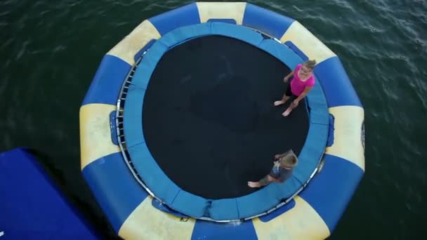 Ludzie, skoki na trampolinie w wodzie — Wideo stockowe