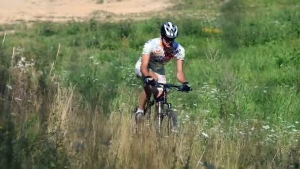 Joven, hombre deportivo montar en bicicleta en día soleado — Vídeo de stock
