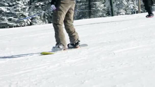 Fechar em pessoas snowboard descendo a encosta — Vídeo de Stock