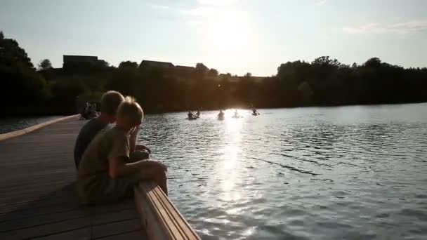 Молодые люди медленно каноэ в озере — стоковое видео