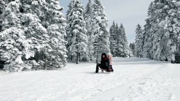 Maman et fille essayant de traîner par temps froid — Video