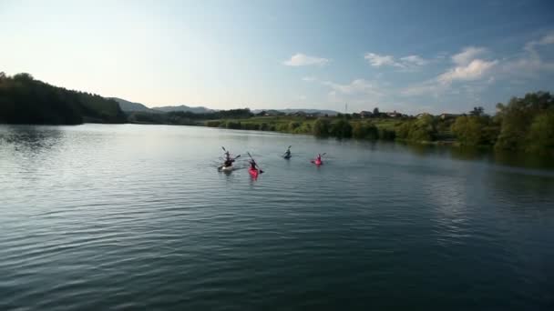 Молодые люди медленно каноэ в озере — стоковое видео
