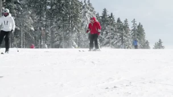 Pessoas que gostam de esqui e snowboard descendo a encosta — Vídeo de Stock