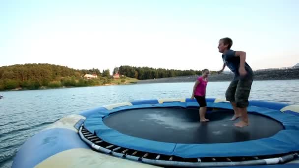 Les gens sautant sur le trampoline dans l'eau 