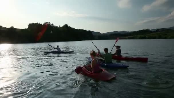 Junge Leute paddeln auf dem See in Richtung Kamera — Stockvideo