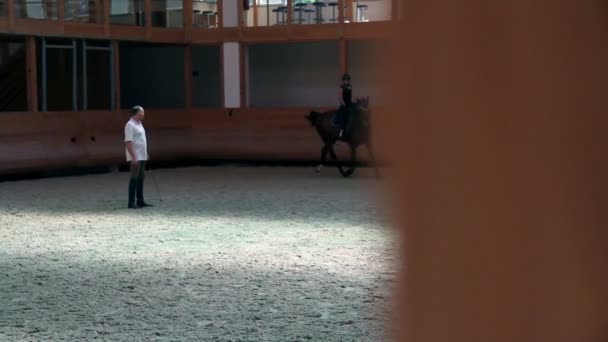 Giovane ragazza a cavallo e di apprendimento con allenatore maschile — Video Stock